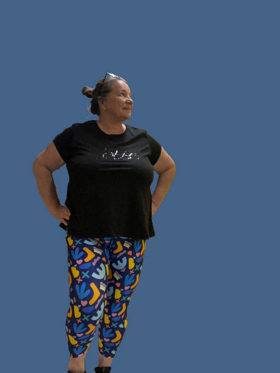 Brenda in the new brightly coloured Happy Dance leggings they have a dark blue background with different shapes in Yellow, light blue, teal 